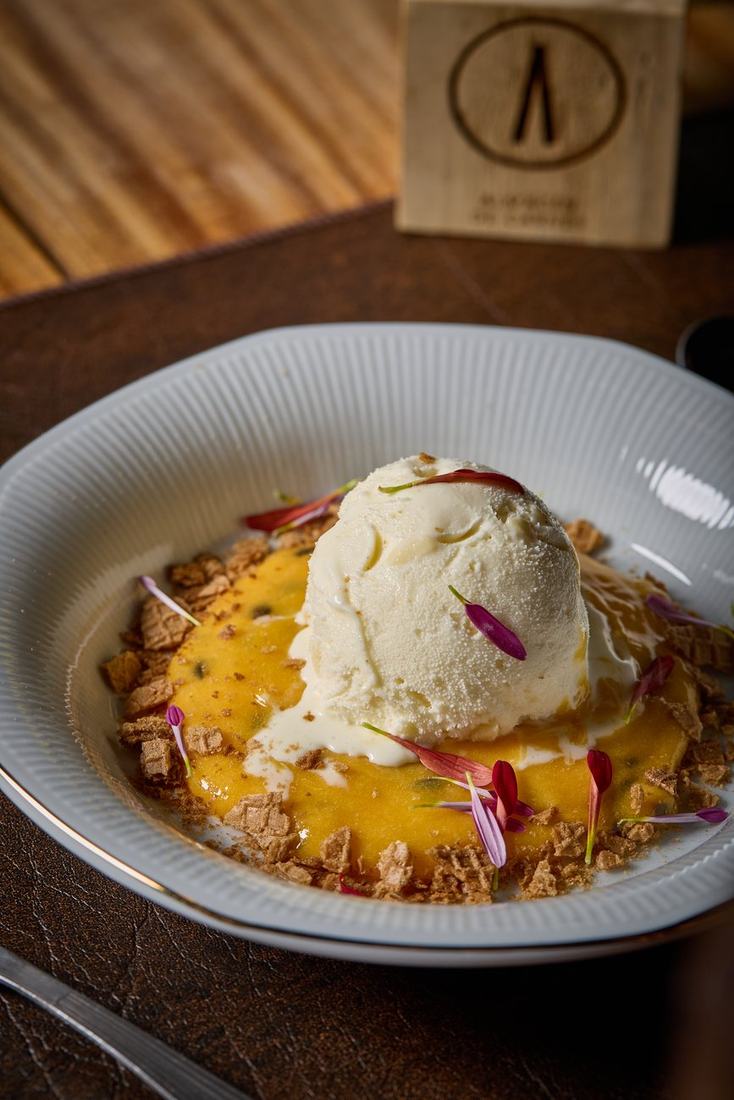 Postre de autor con helado y curd de maracuyá